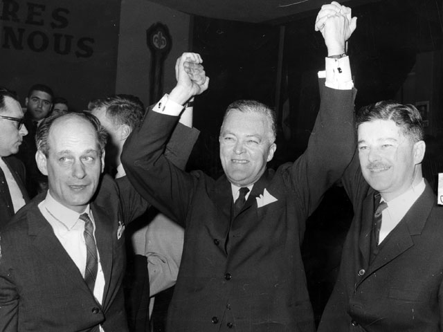 Jean Lesage, célèbrant la victoire des siens en compagnie de ses deux candidats vedettes, René Lévesque et Paul Gérin-Lajoie